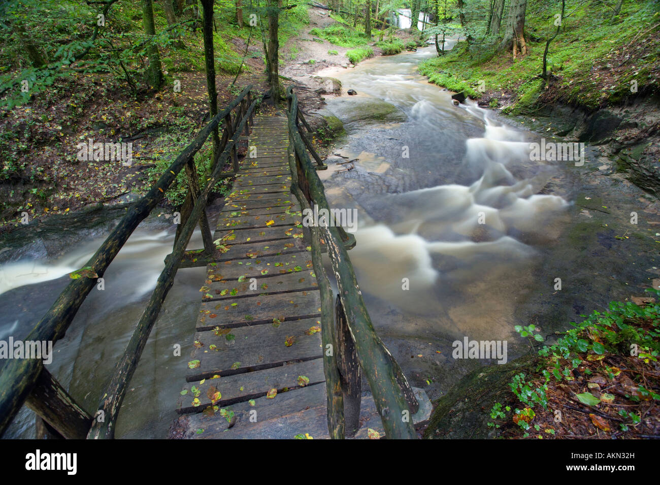 Wooden bridge across a small river Stock Photo - Alamy