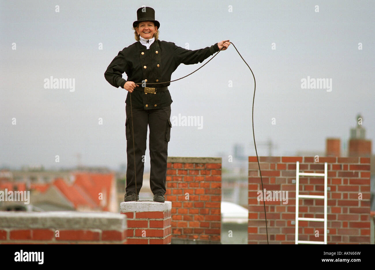 Female chimney sweeper on a roof, Berlin, Germany Stock Photo