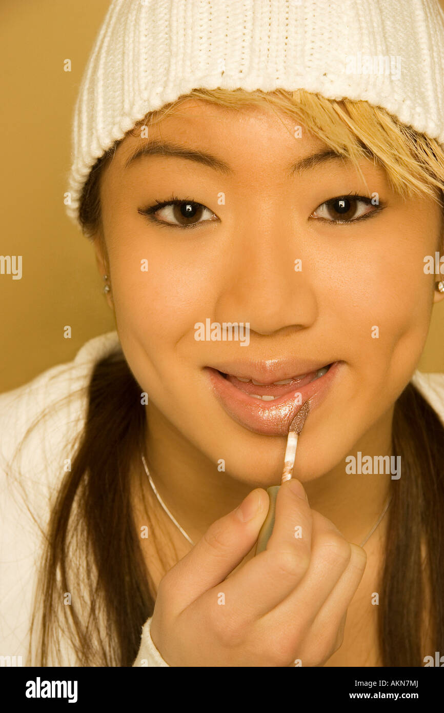 Woman applying lip gloss Stock Photo