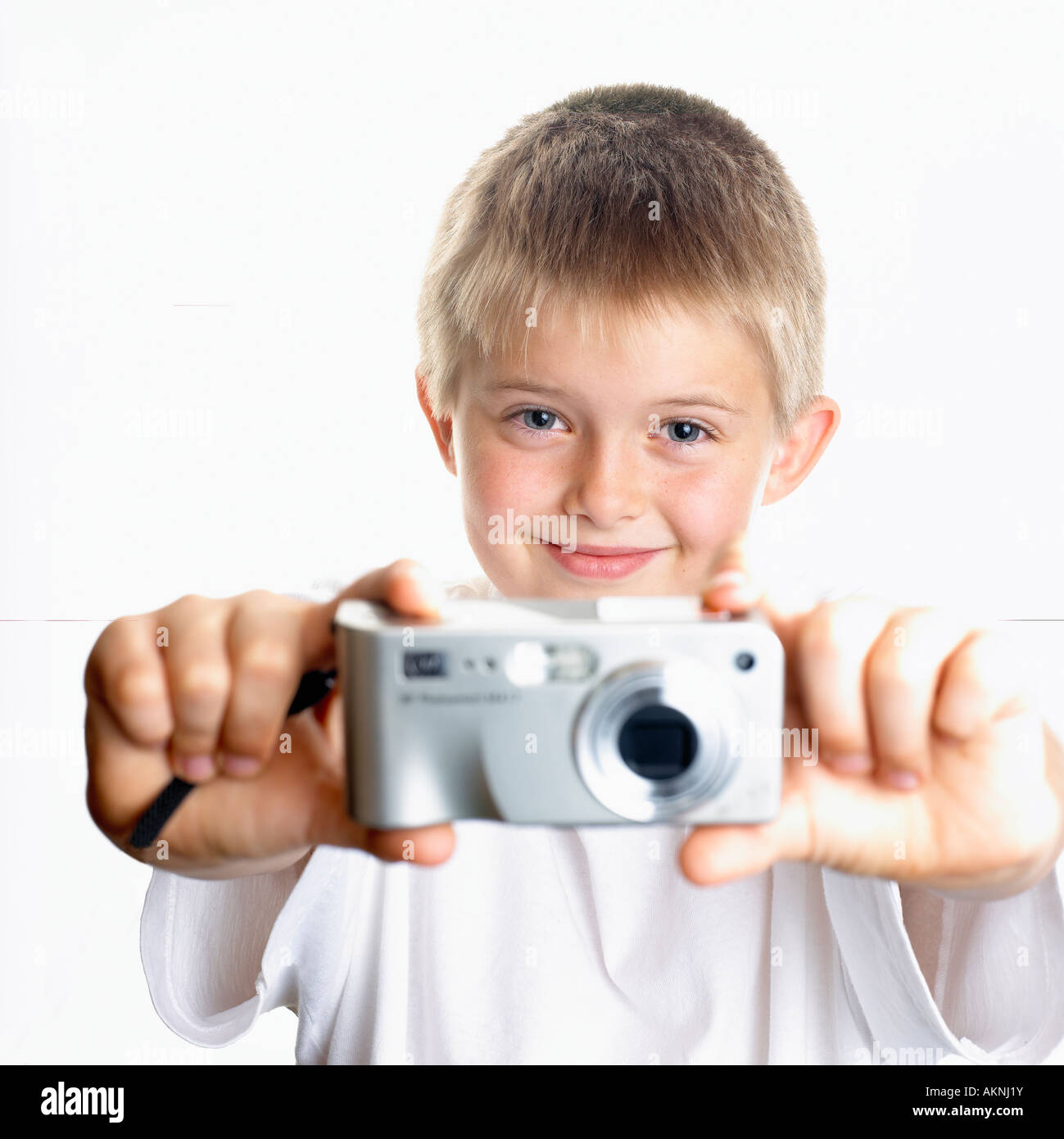 Image of young boy holding digital point and shoot camera Stock Photo