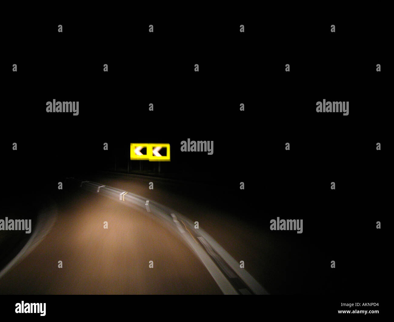 Sharp left turn concept on dark road Stock Photo
