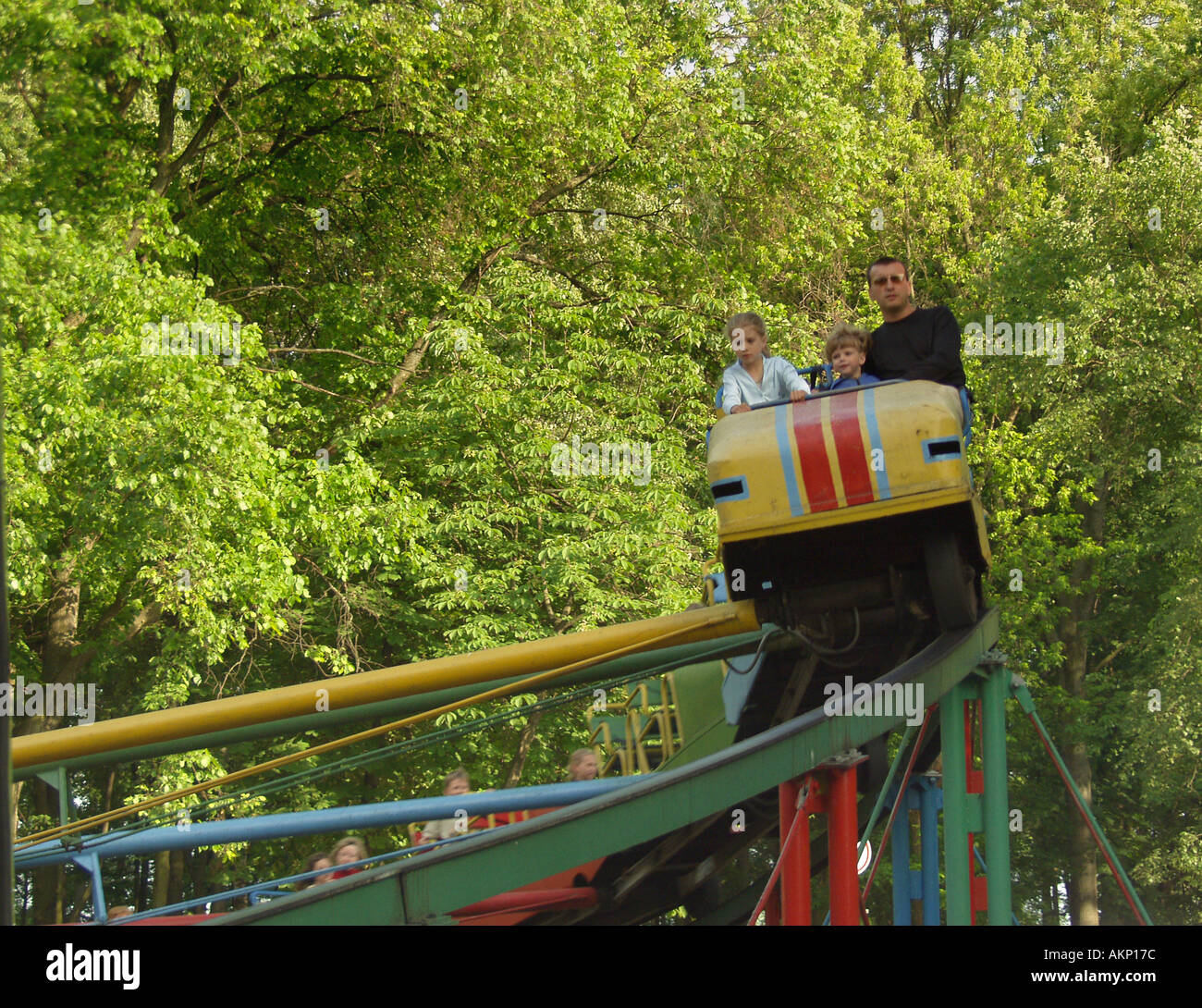 Rollercoaster in motion with passengers at traditional fairground in Gomel Park, Gomel, Belarus Stock Photo