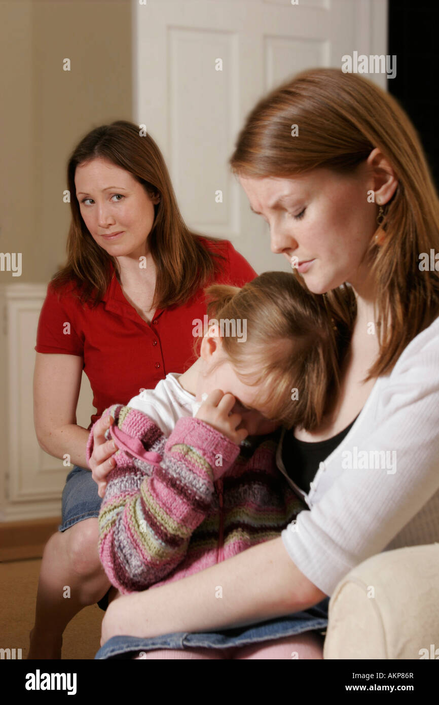 Upset little girl with mother and concerned woman Stock Photo