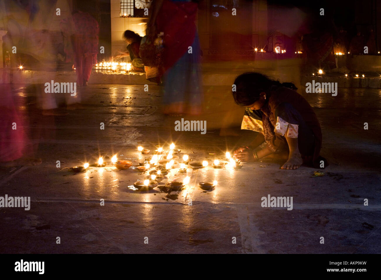 Indian girl in a hindu temple at a Diwali festival in Puttaparthi, Andhra Pradesh, India.Hindu festival of lights. Taken with a long exposure Stock Photo