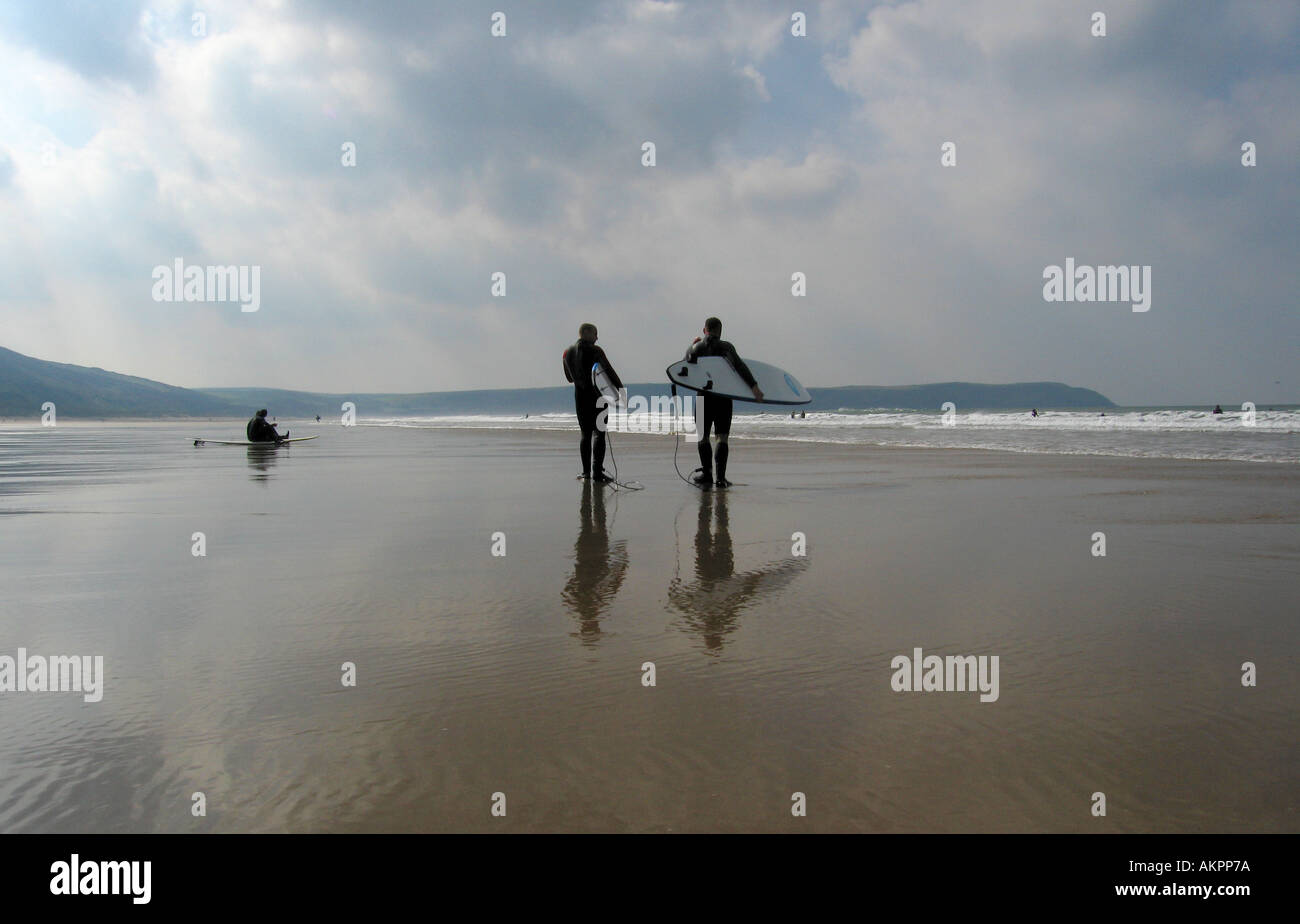 two surfers walking on beach Stock Photo