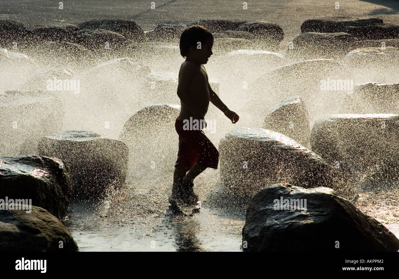 A child plays in a fountain outside the Science Center in Harvard University Cambridge Massachusetts Stock Photo