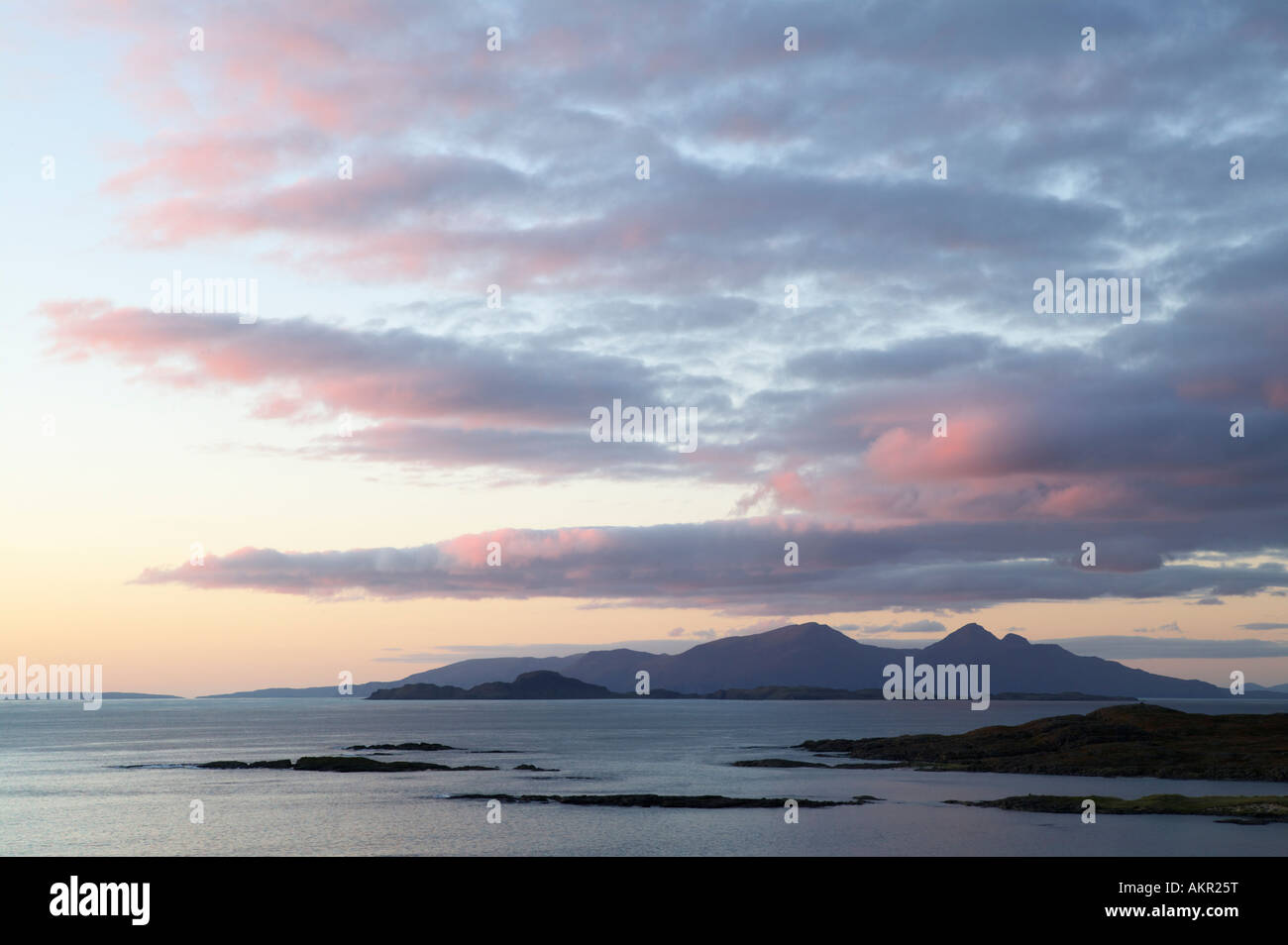 The Isles of Muck and Rum at sunset viewed from Sanna Bay, Ardnamurchan, Lochaber, Highland, Scotland, UK Stock Photo