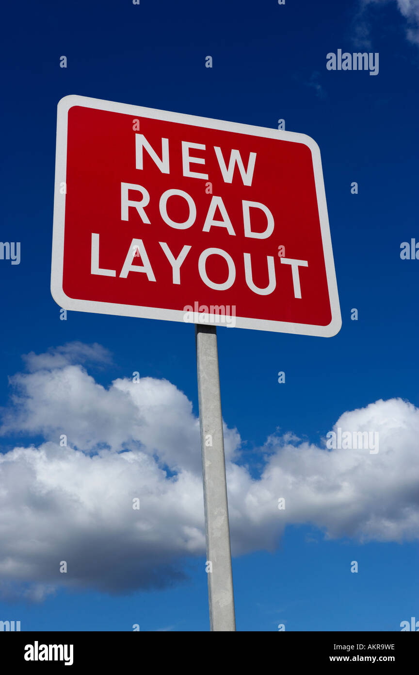 RED NEW ROAD LAYOUT WARNING SIGN WITH BLUE SKY AND WHITE CLOUDS IN BACKGROUND Stock Photo