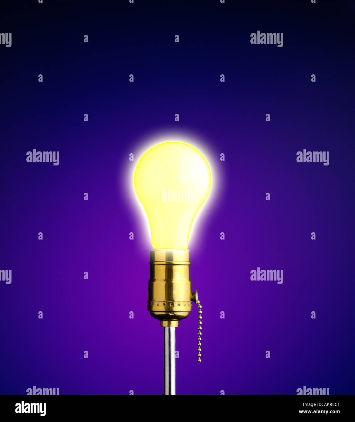 lightbulb glowing against blue background Stock Photo
