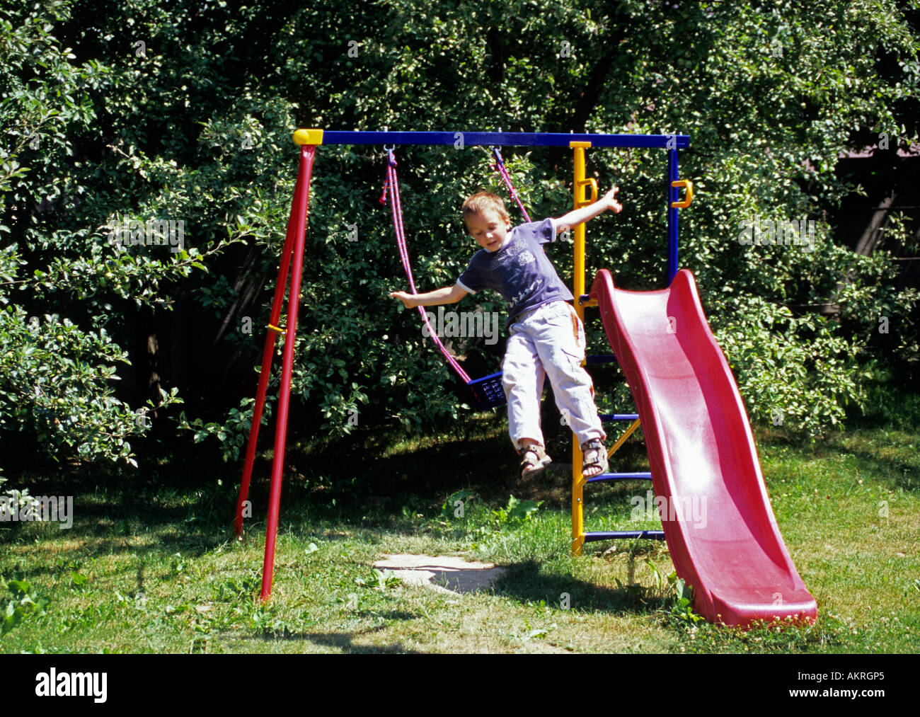 Boy jumping from a swing seesaw, danger Stock Photo