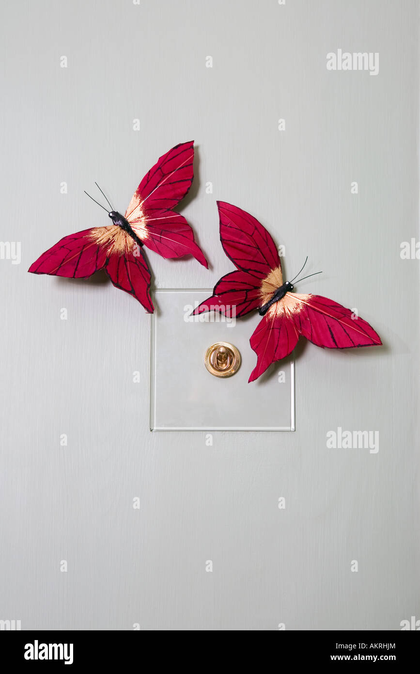 Fake butterflies on a lightswitch Stock Photo