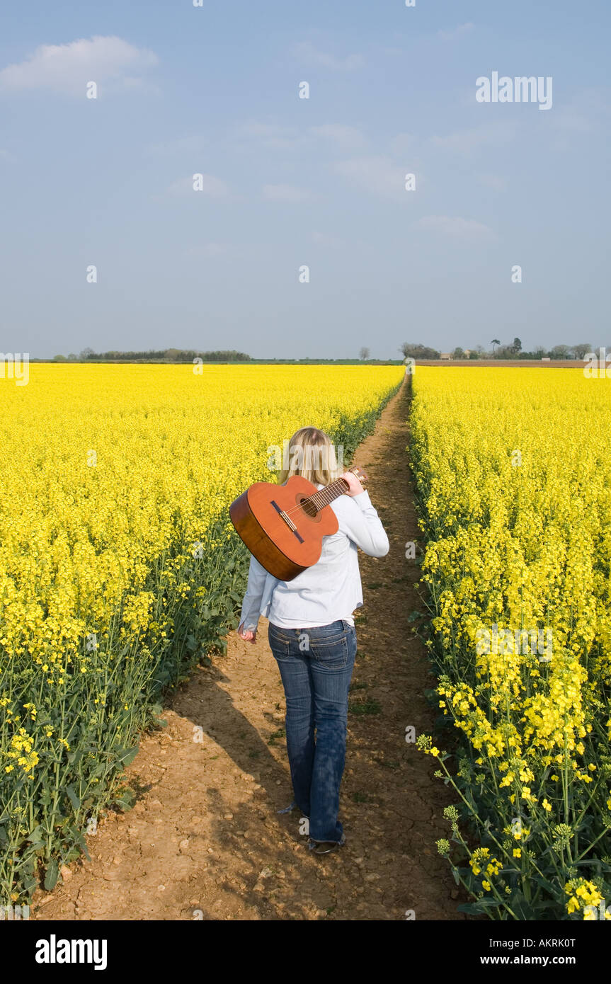 Woman in field with guitar Stock Photo