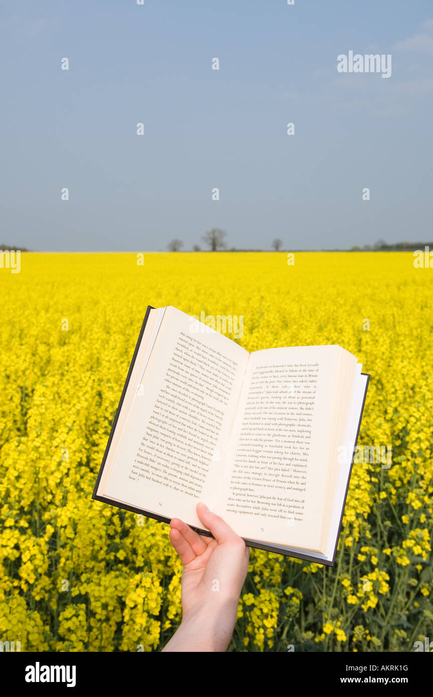 Person with book in field Stock Photo