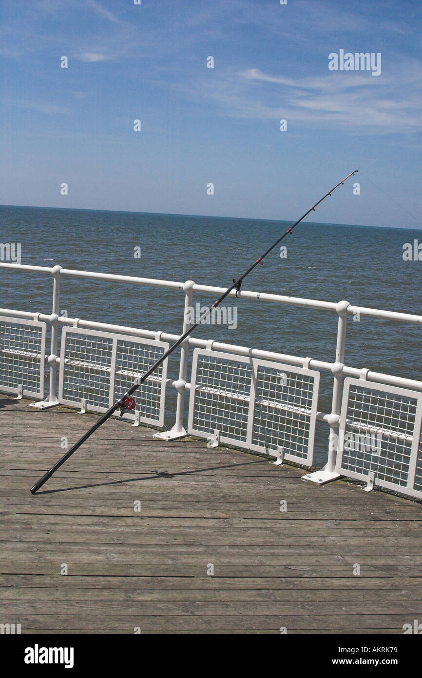 fishing rod hanging over the side of a pier at blackpool uk Stock