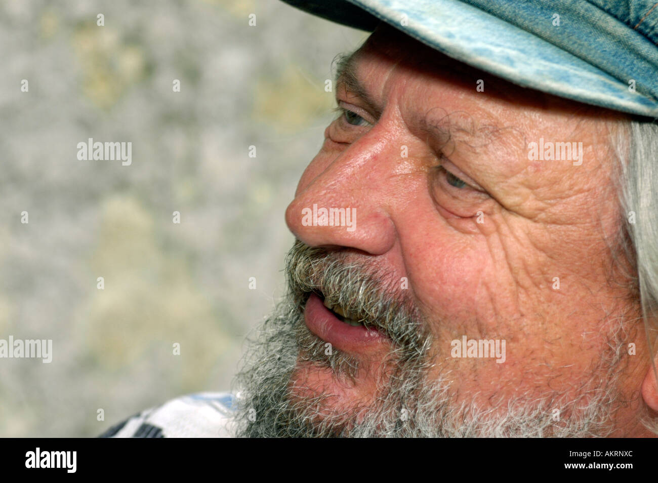 portrait of a bearded man in age of about 55 to 65 years with a peaked cap Stock Photo