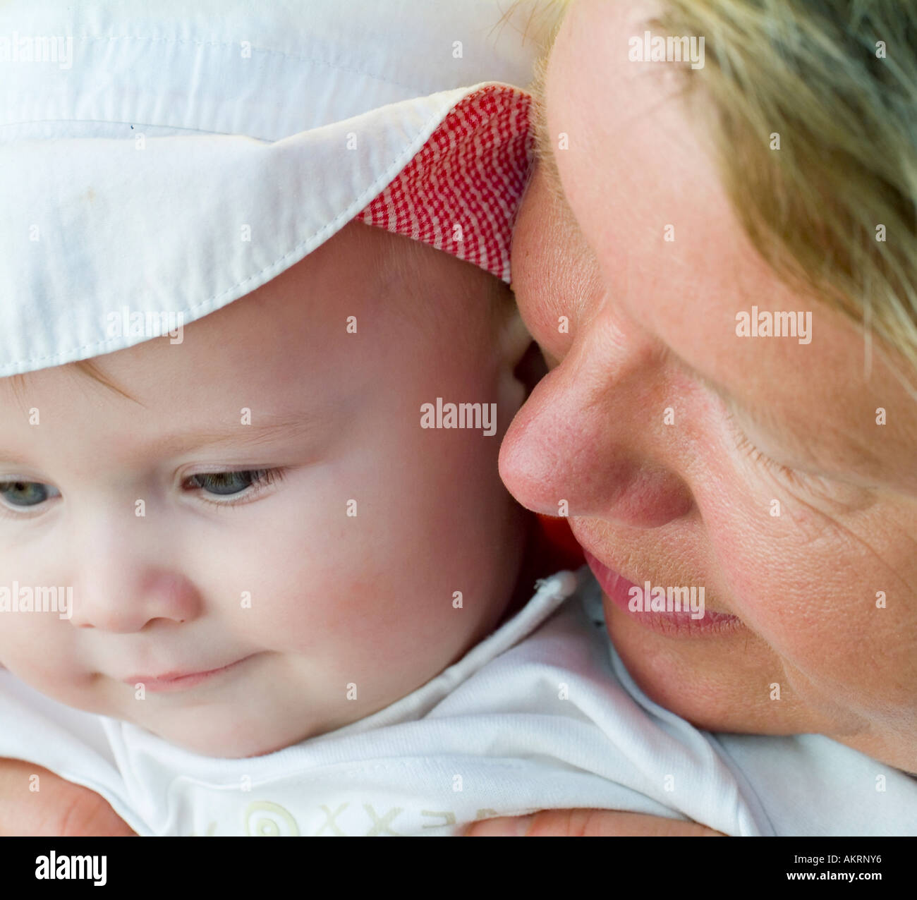 grandmother and grandchild portrait of a baby of 8 months with sun hat and a woman in age of about 45 to 55 years Stock Photo