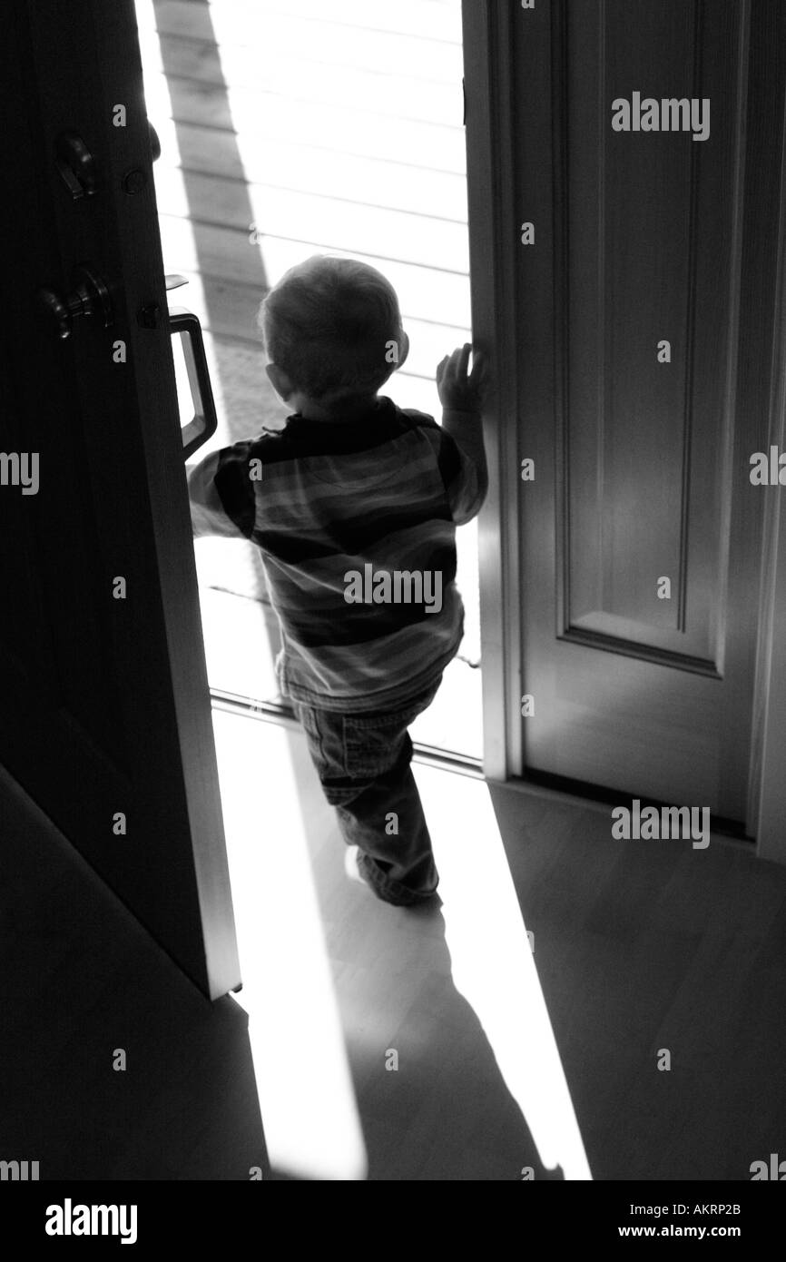 Toddler walking out an open door Stock Photo Alamy