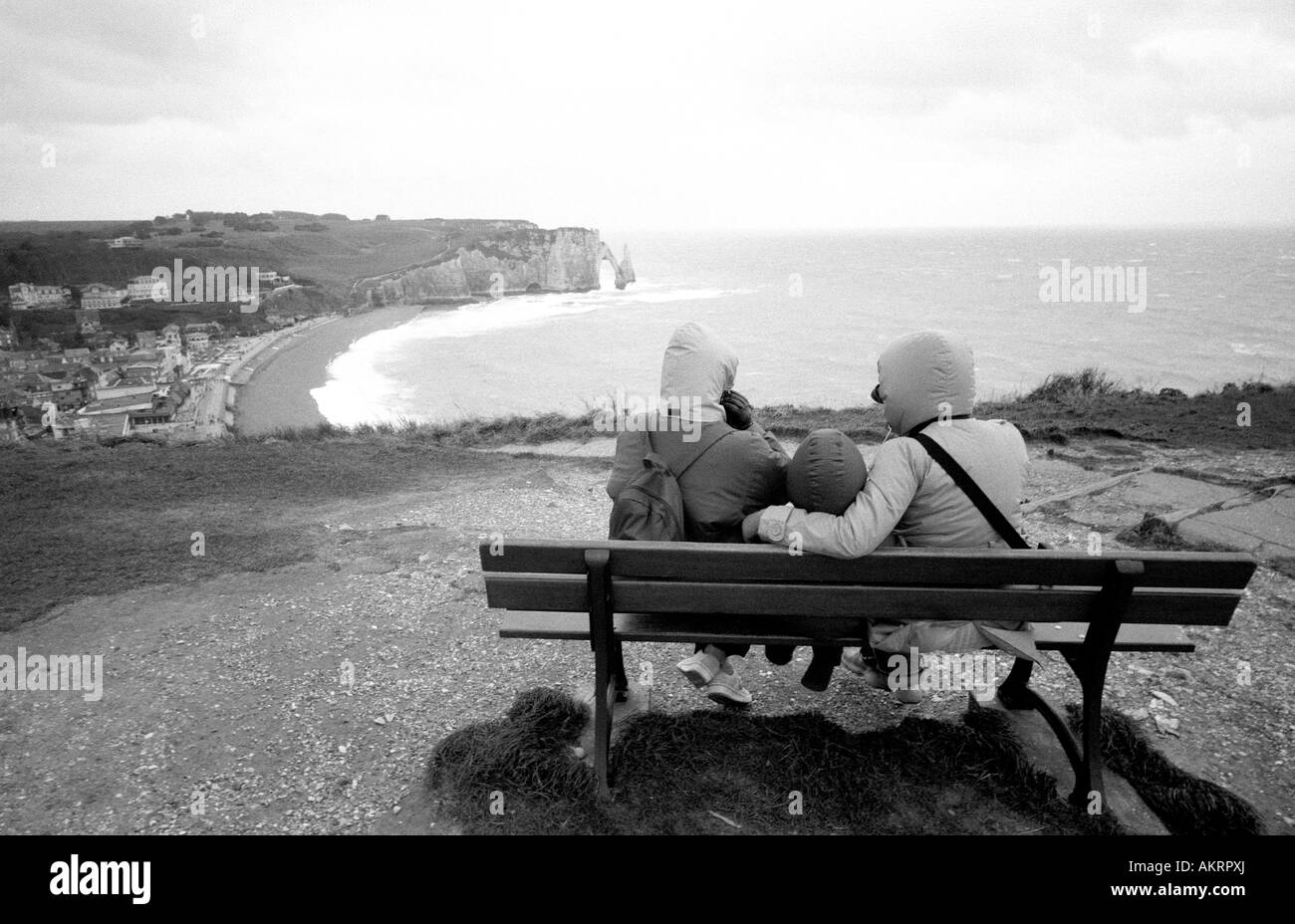 Three people sitting bench Black and White Stock Photos & Images - Alamy
