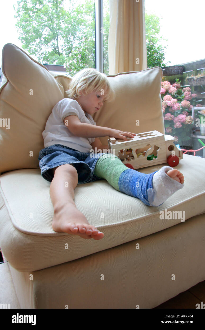 Little boy with a broken leg playing with a toy Stock Photo Alamy