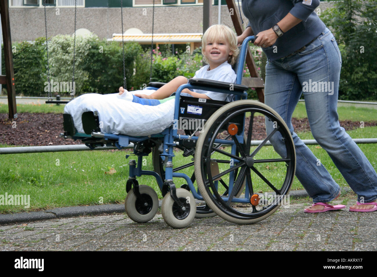 Little boy with a broken leg sitting in a wheelchair Stock Photo