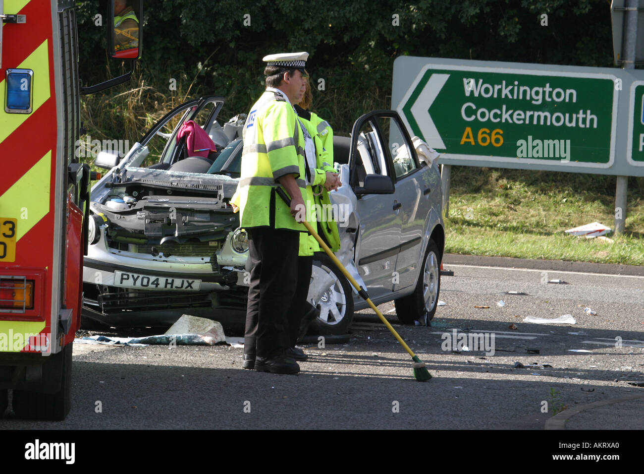 Police Officer cleaning up after a road traffic accident Stock Photo