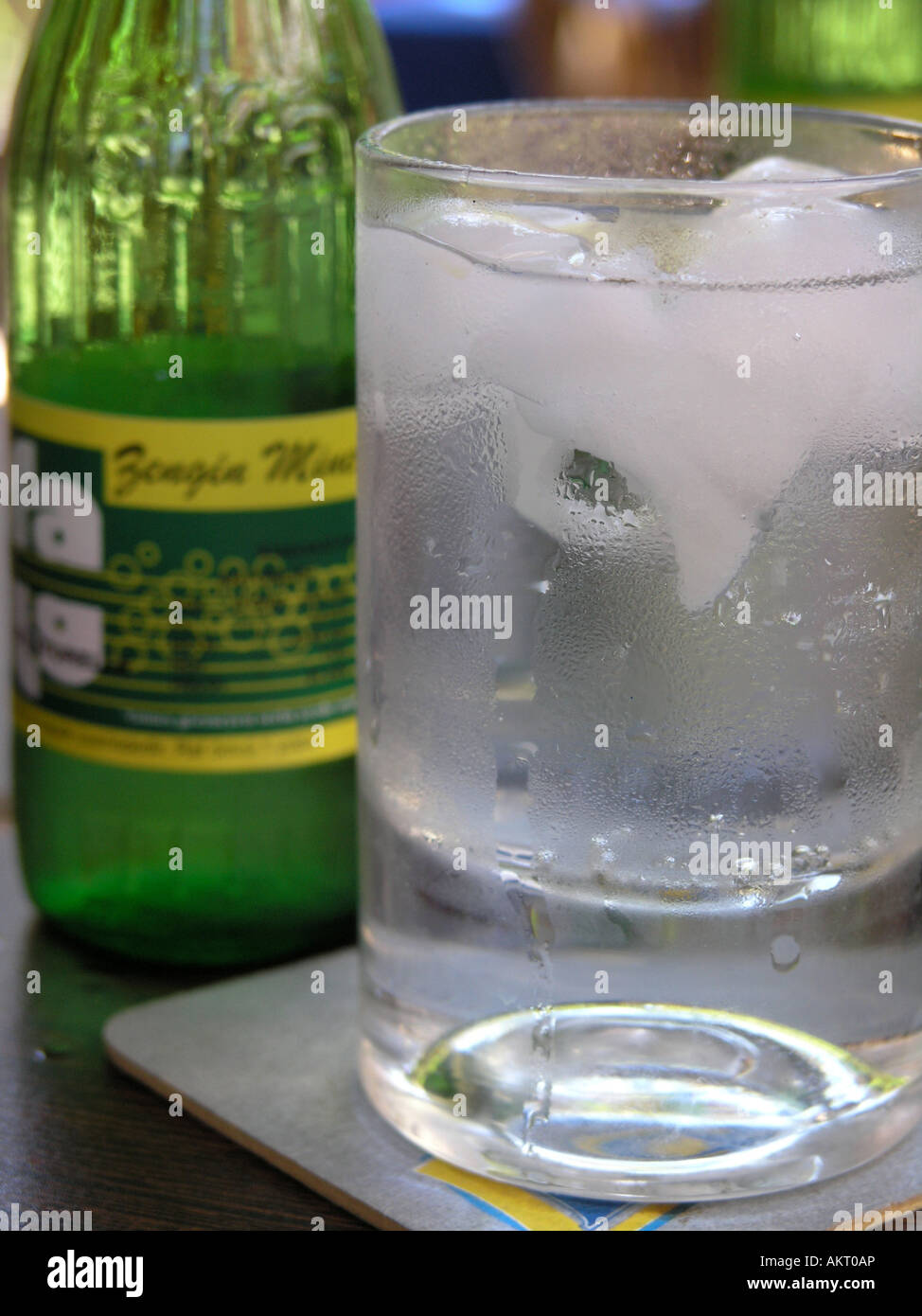 Glass of mineral water with ice and a green glass bottle Stock Photo ...