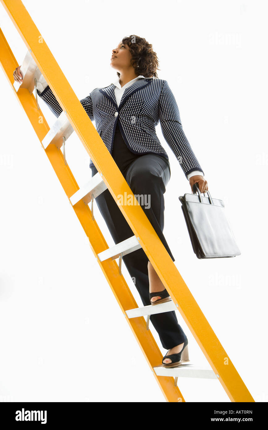 Businesswoman holding briefcase climbing ladder Stock Photo Alamy