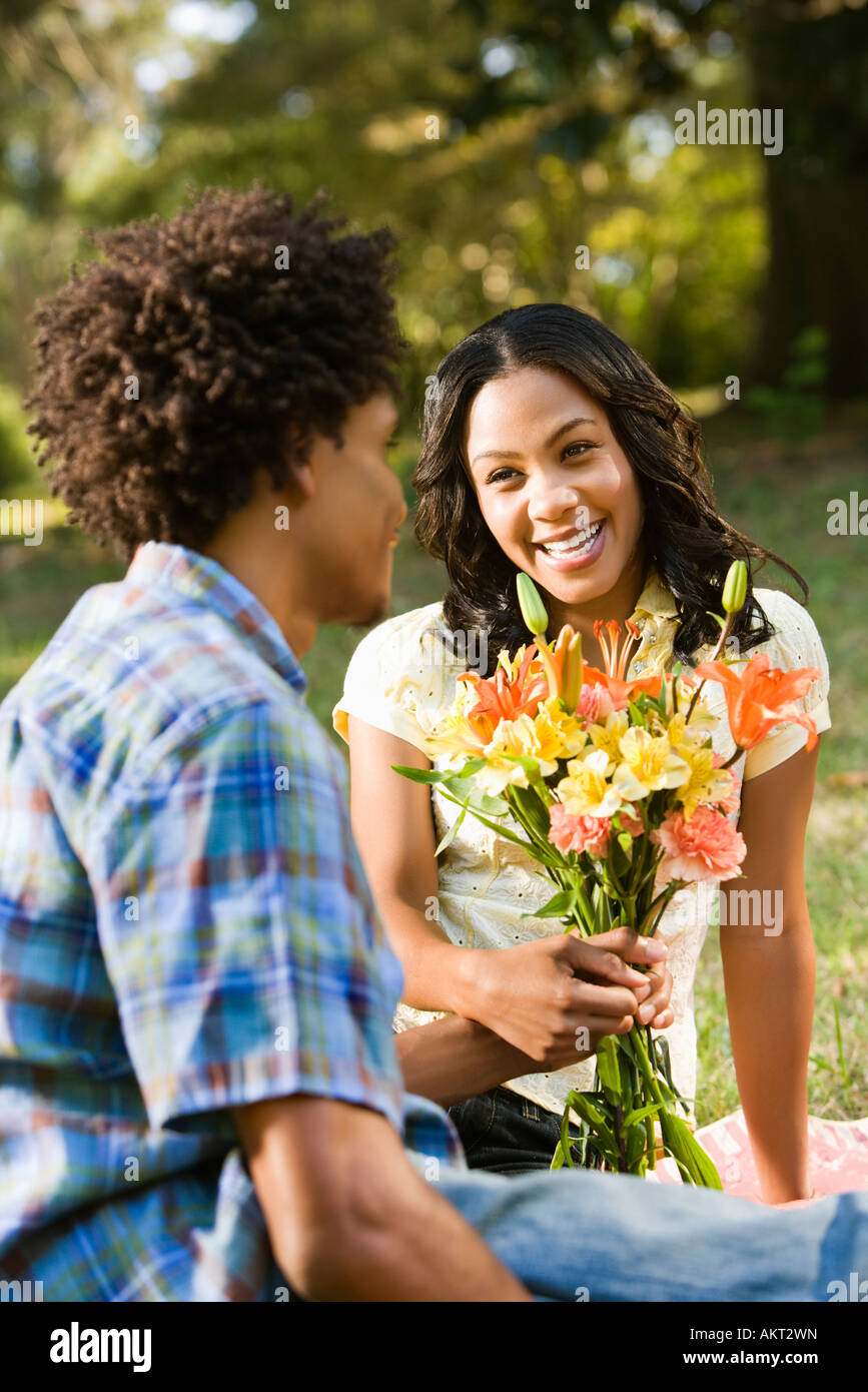 Man giving smiling woman bouquet of flowers Stock Photo - Alamy