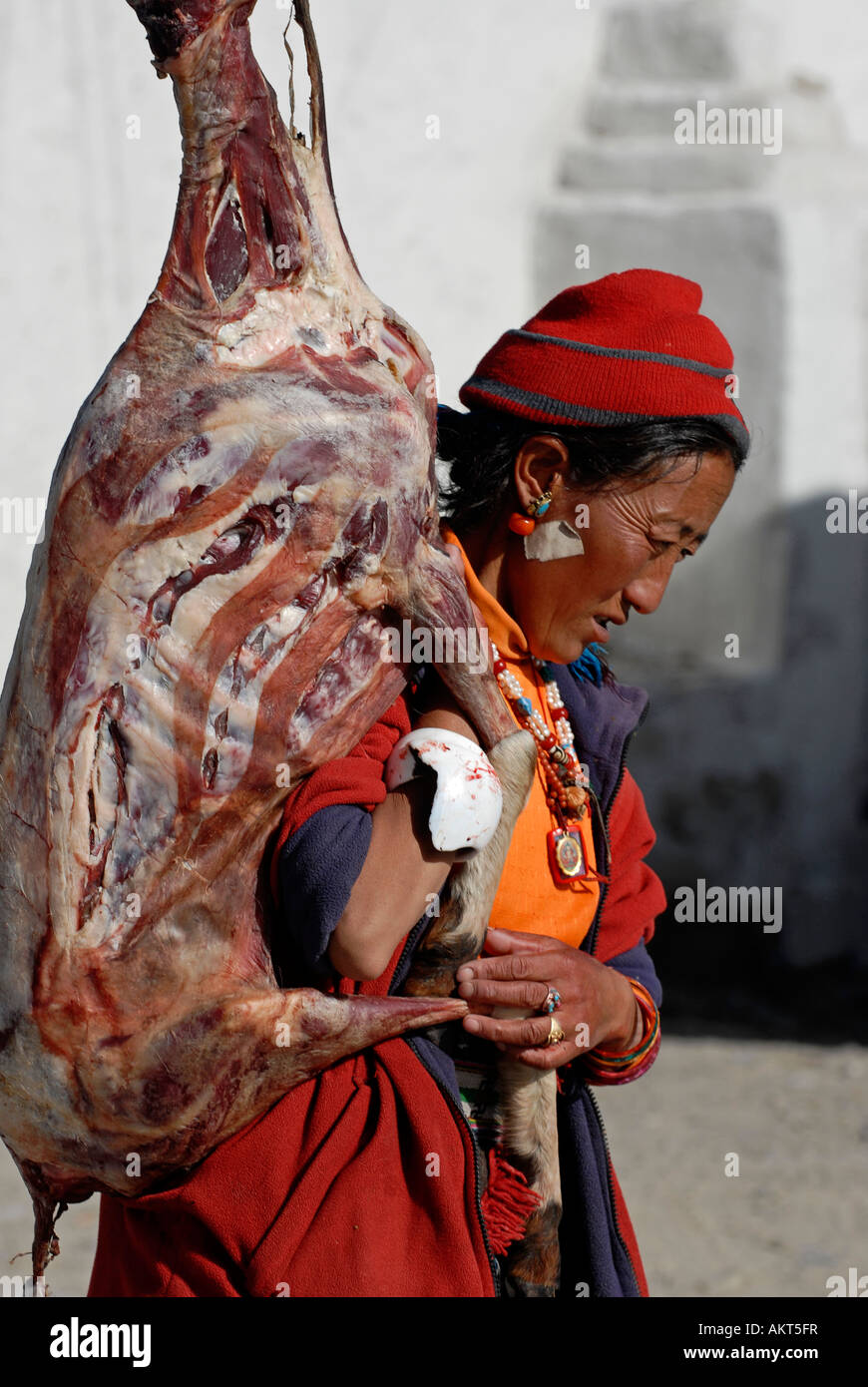 A tibetan man carrying an animal carcass Stock Photo