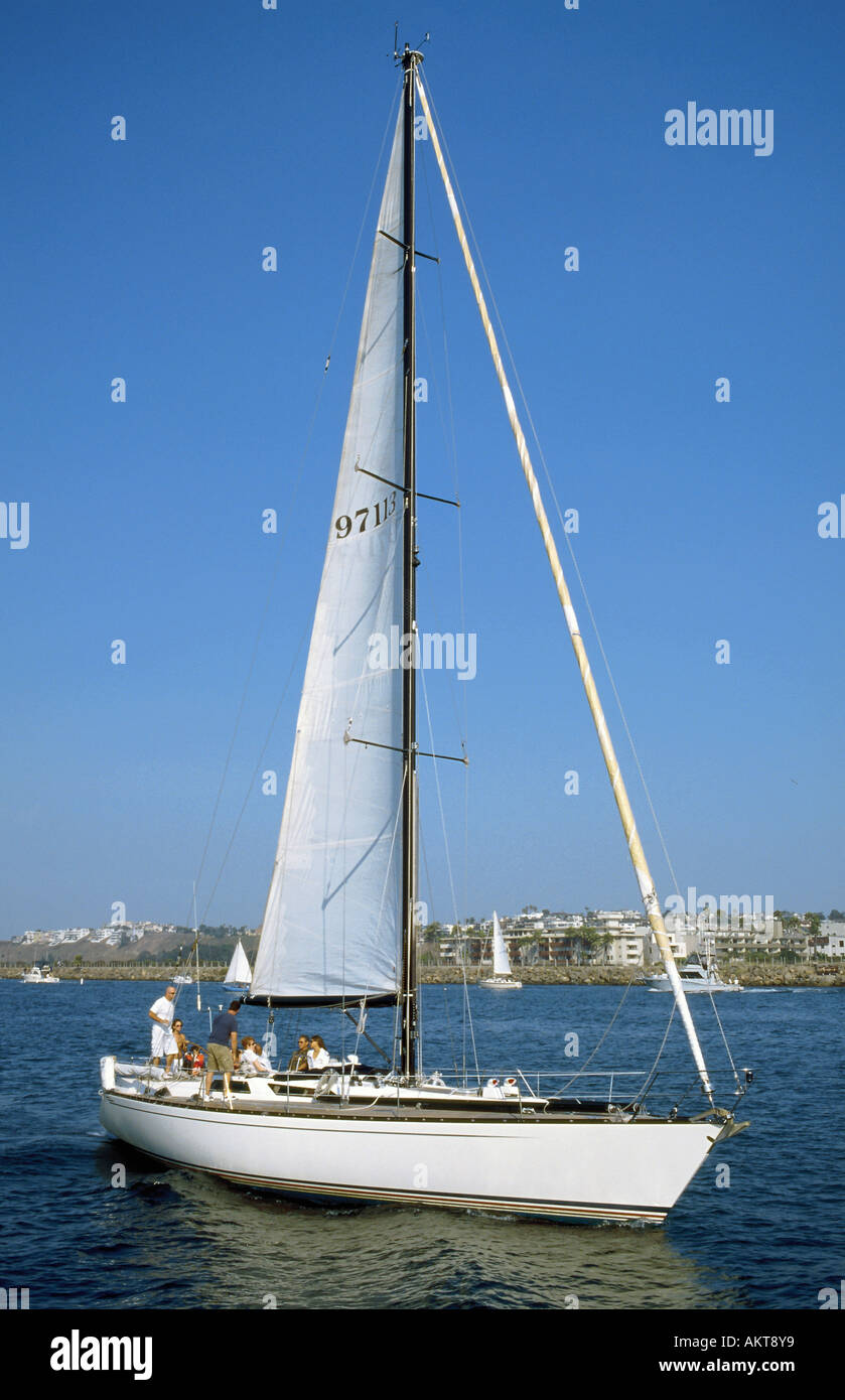 Sailboat leaving Marina del Rey through the main channel for a Sunday trip on the Pacific Ocean Stock Photo