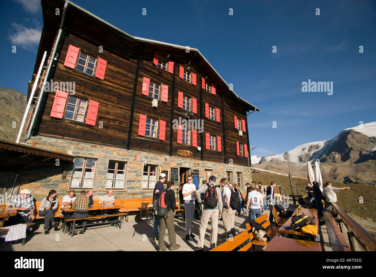 Hikers resting on the terrace of the Alpine hut Fluhalp Zermatt Valais Switzerland Stock Photo