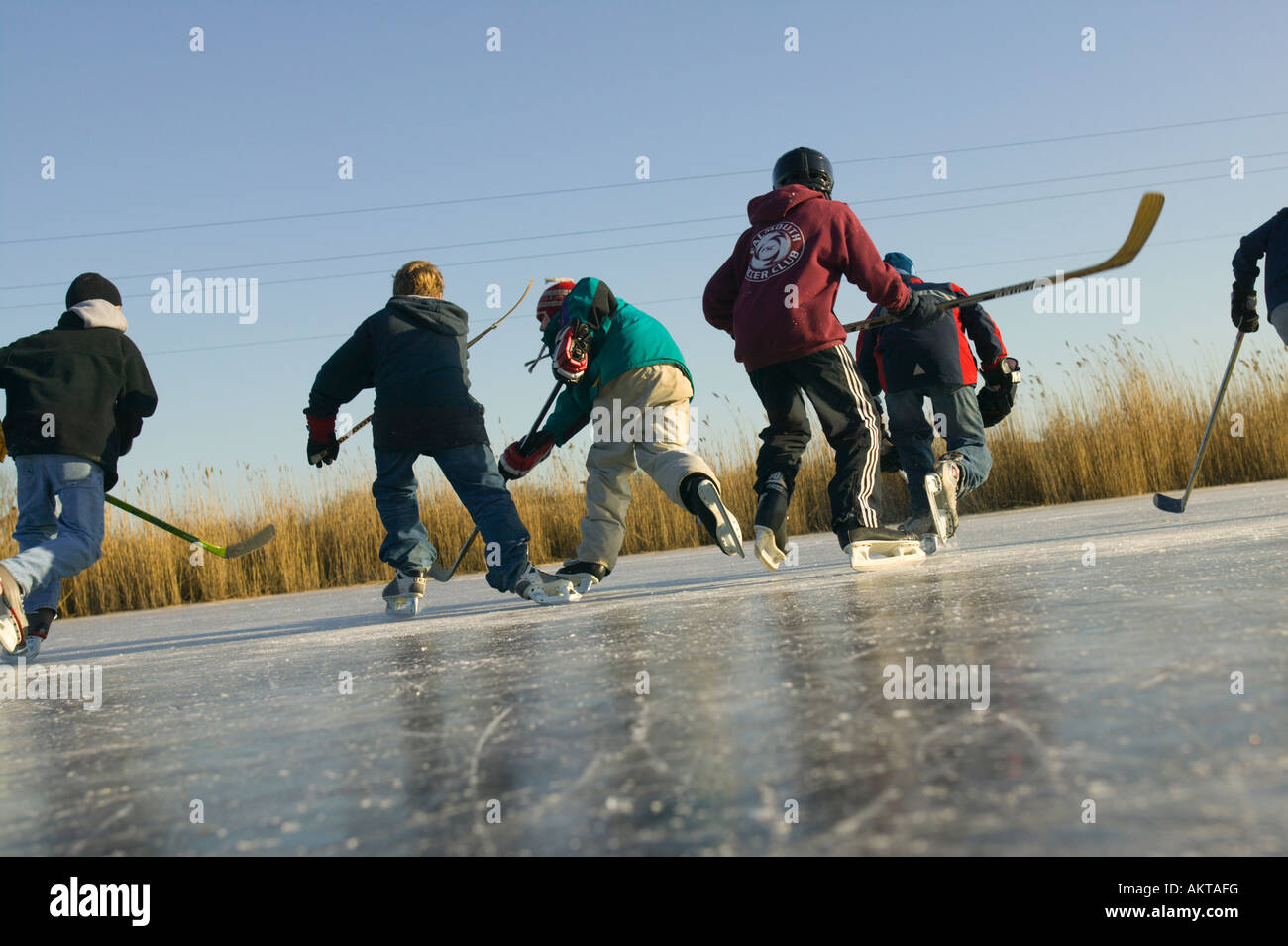Boys Skating on Frozen Pond Stock Photo