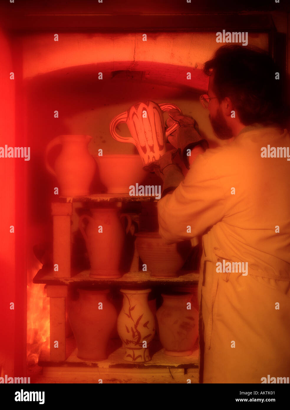 ceramic artist place pot pottery into fired kiln oven for drying Stock