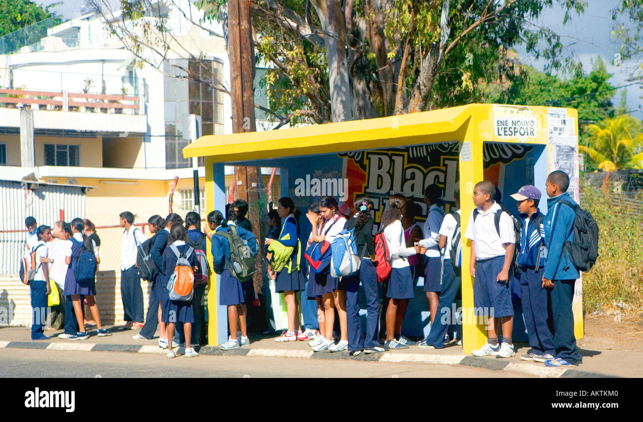 School children waiting for bus home after school - "Mauritius". Stock Photo