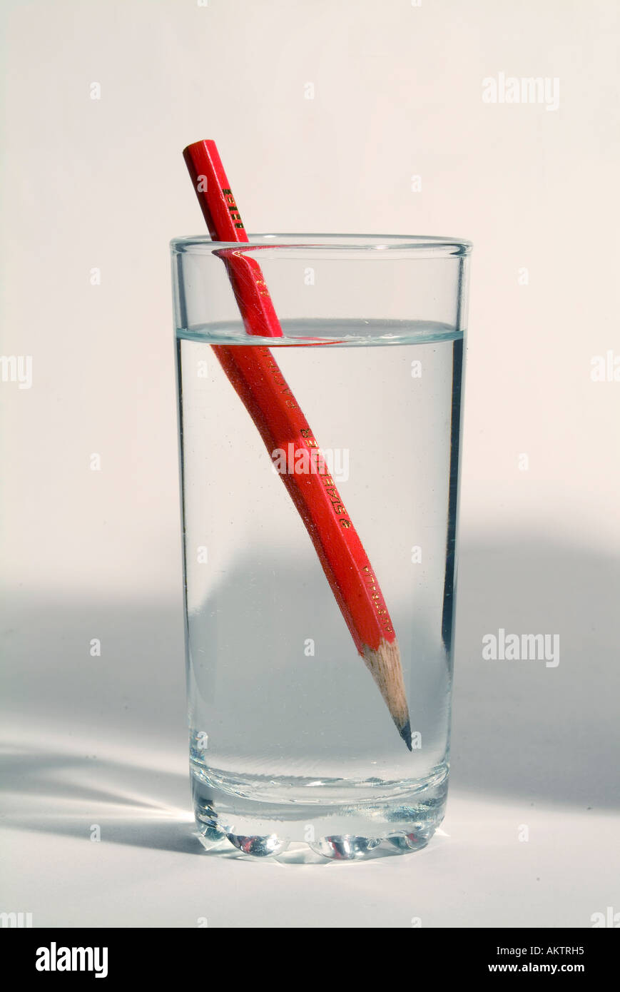 A pencil in a glass of water showing the optical distortion caused by refraction of the image Stock Photo