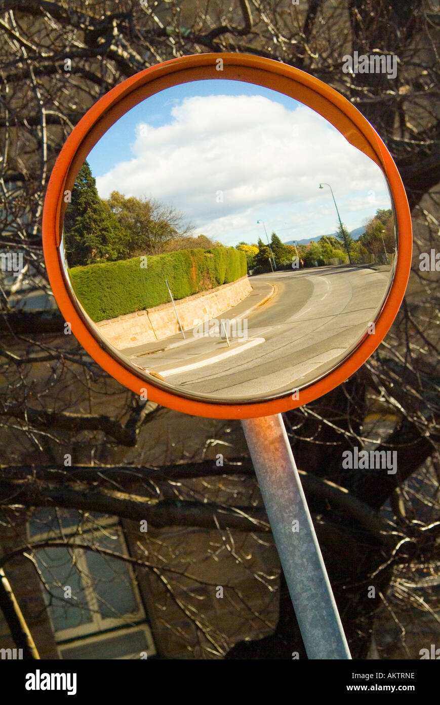A convex mirror used to see around a blind corner Stock Photo