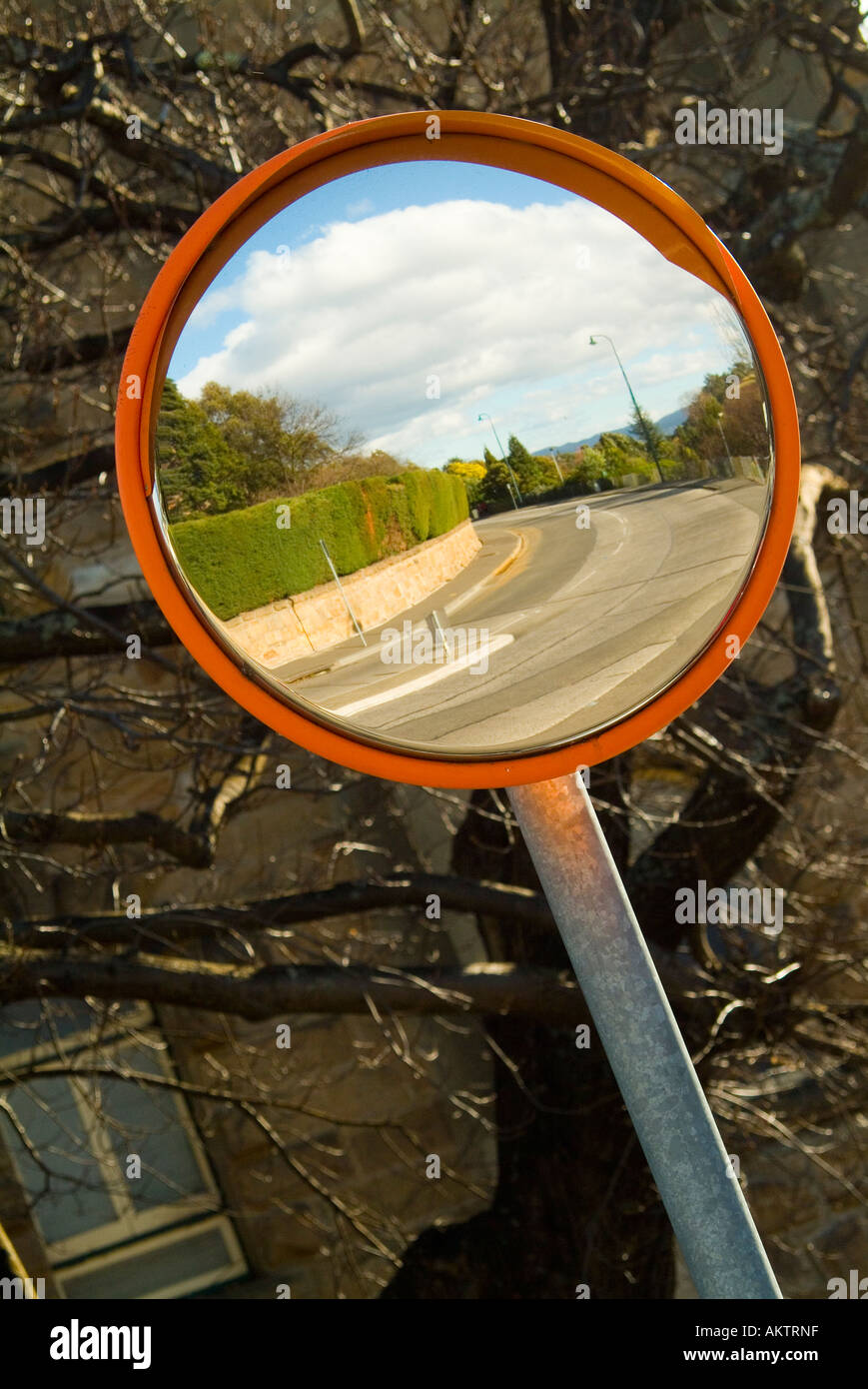 A convex mirror used to see around a blind corner Stock Photo