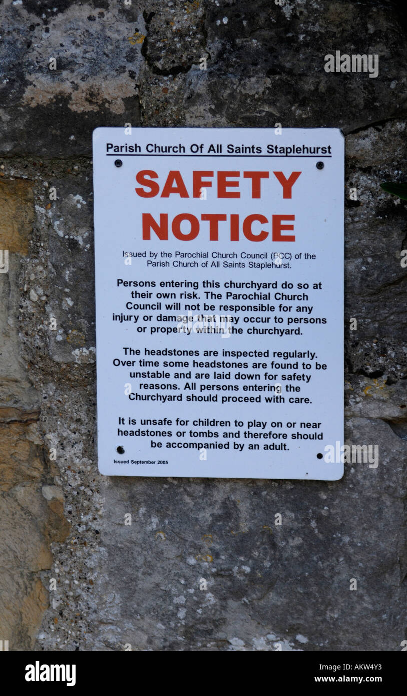 Safety Notice at All Saints Church Staplehurst warning that persons who enter the churchyard do so at their own risk Stock Photo