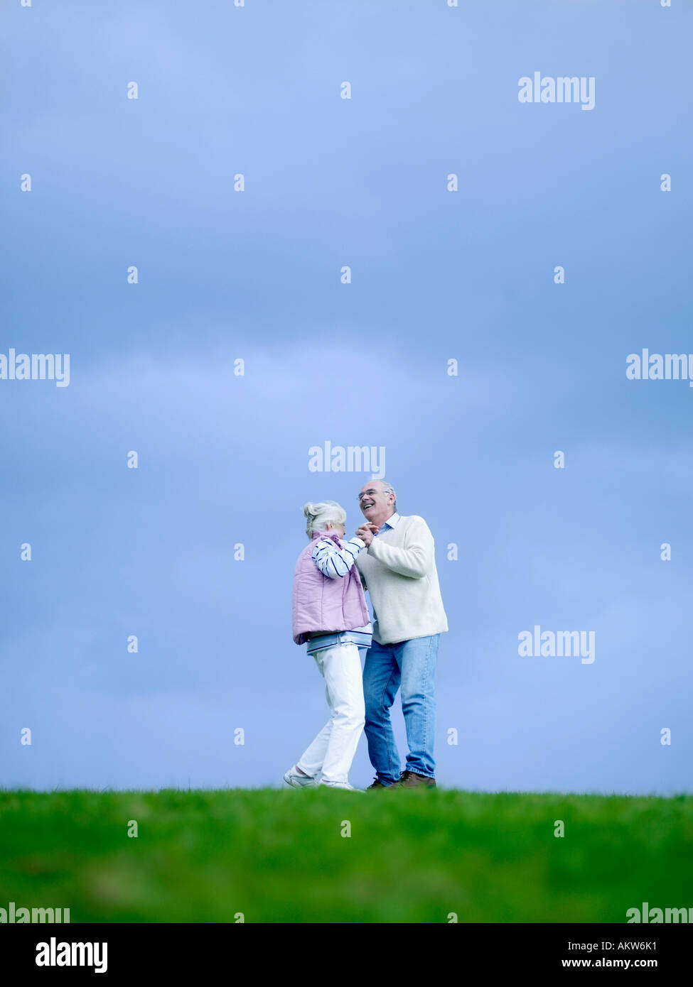 Senior couple embracing outdoors, (low angle view) Stock Photo