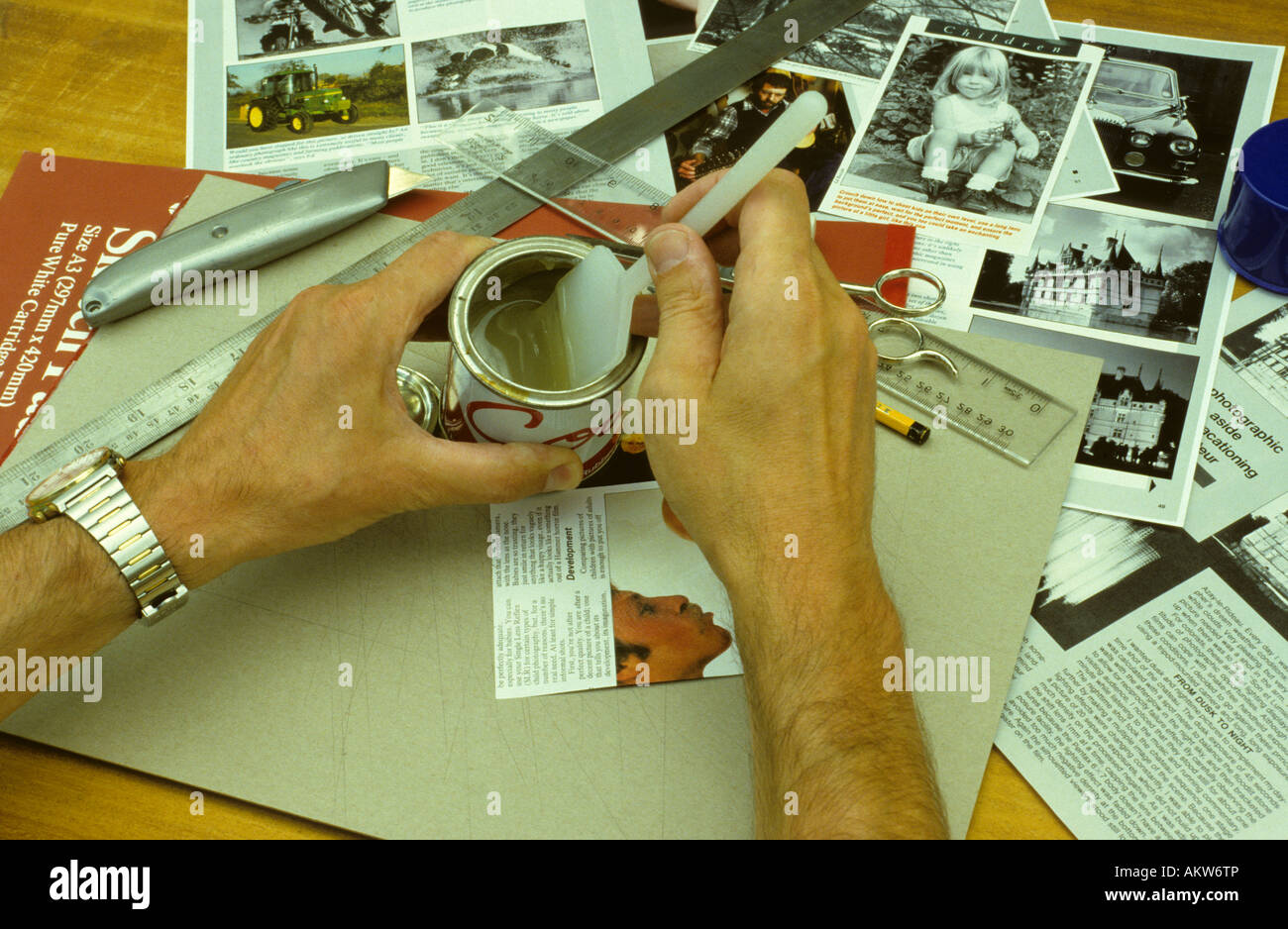 Sticking paper to board with contact adhesive. Stock Photo