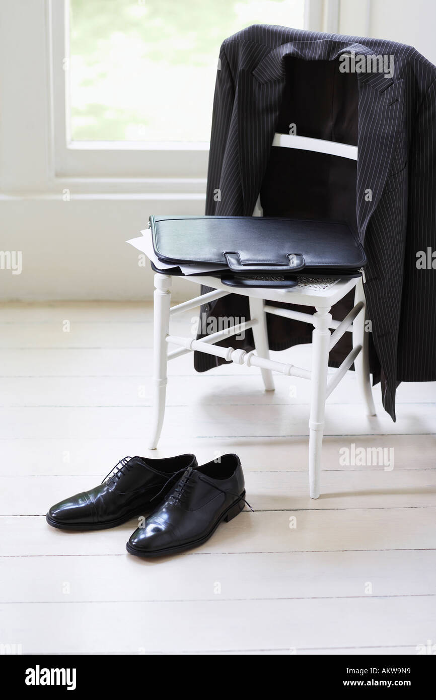 Clothing of businessman on chair and floor Stock Photo