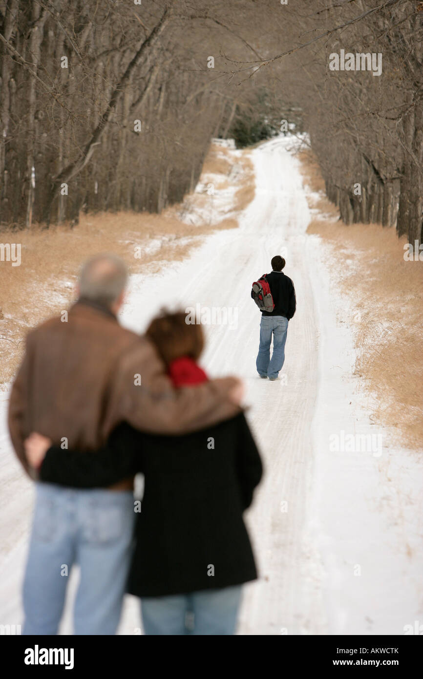 A teenage boy walking down a snow-covered path Stock Photo