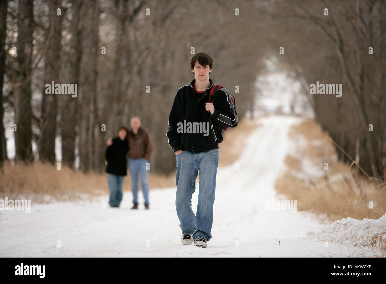 A teenage boy walking away from his parents Stock Photo