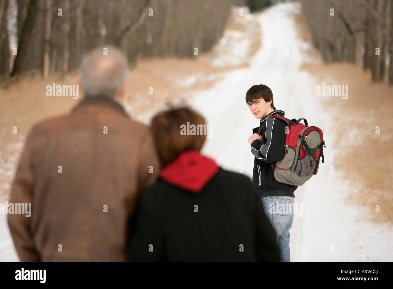 A teenage boy walking on a snow-covered path Stock Photo