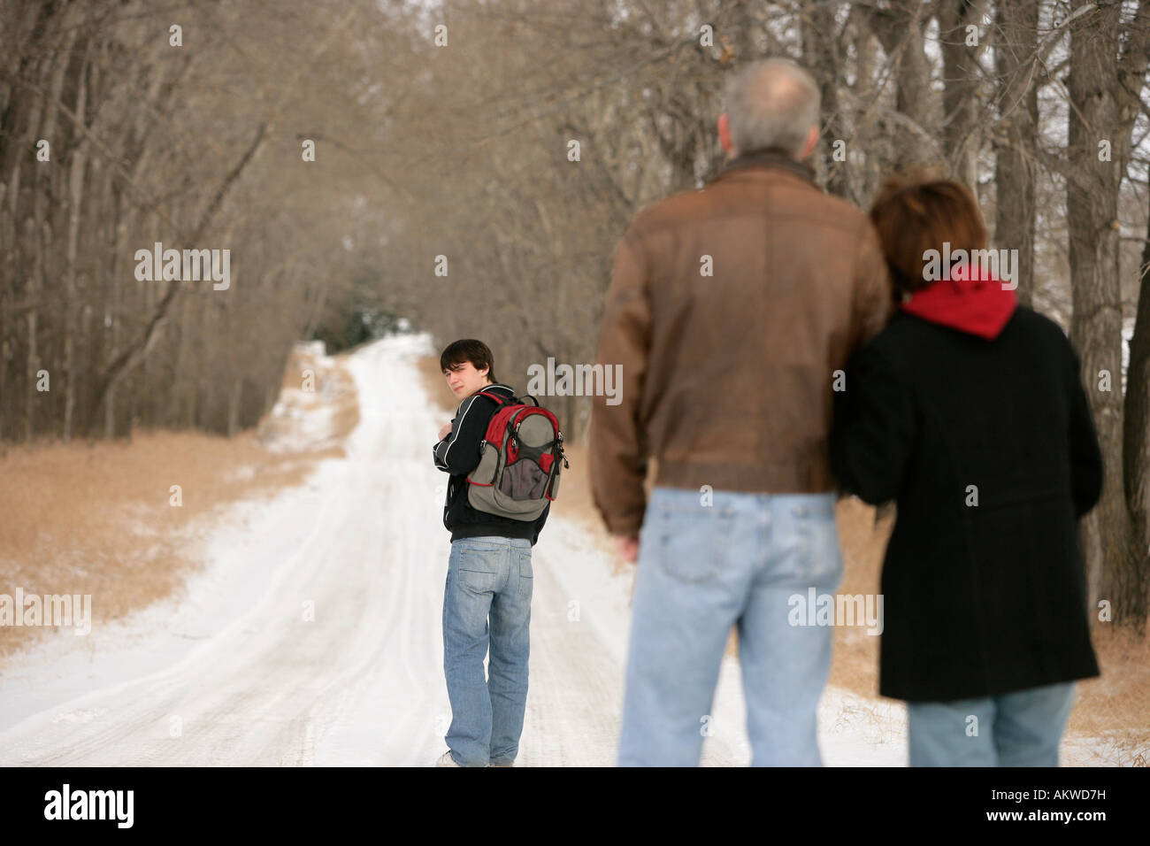 A teenage boy walking on a snow-covered path Stock Photo