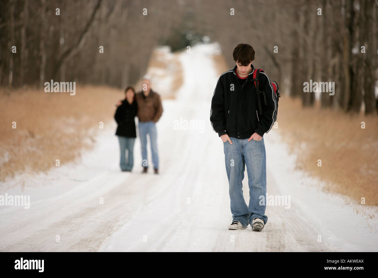 A teenage boy walking away from his parents Stock Photo