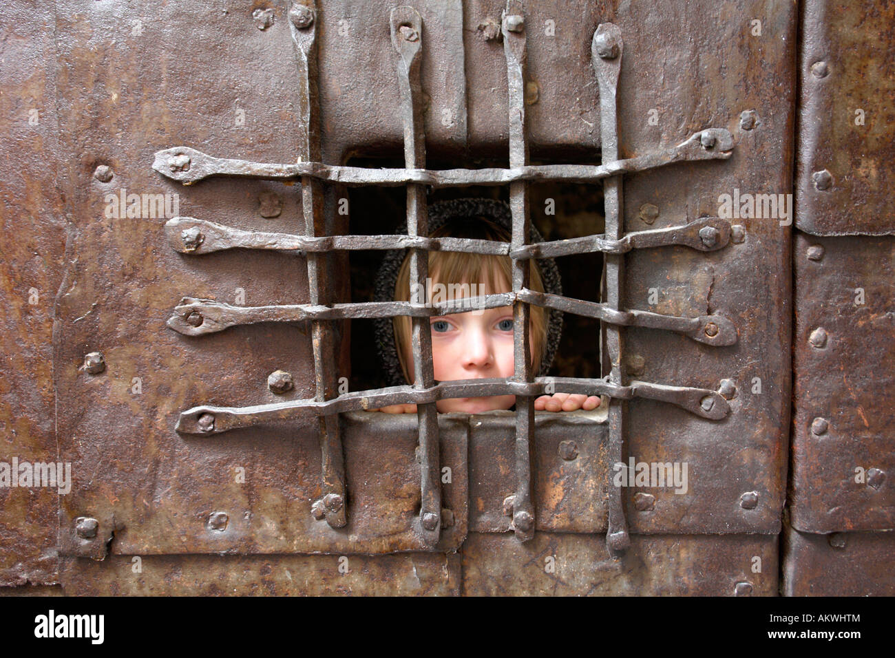 Italy, South Tyrol, Potrait of a girl behind bars Stock Photo