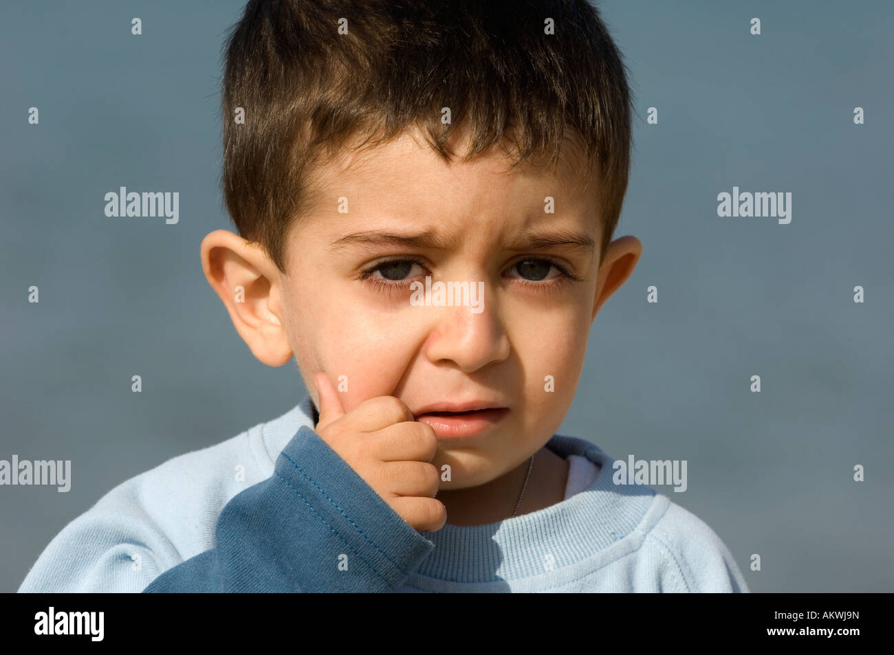 baby boy crying hand on mouth Stock Photo