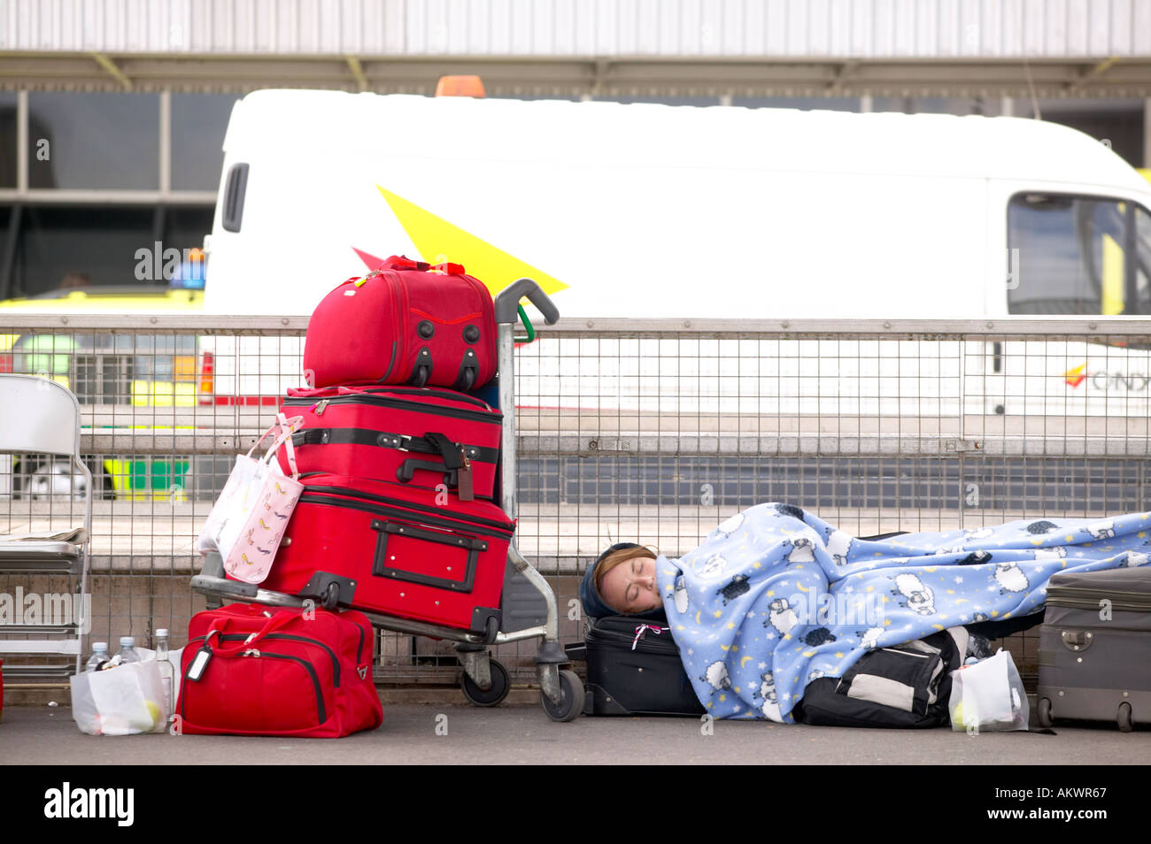 A woman sleeps with her baggage outside terminal four during a strike at Heathrow Terminal Four London UK 2005 Stock Photo