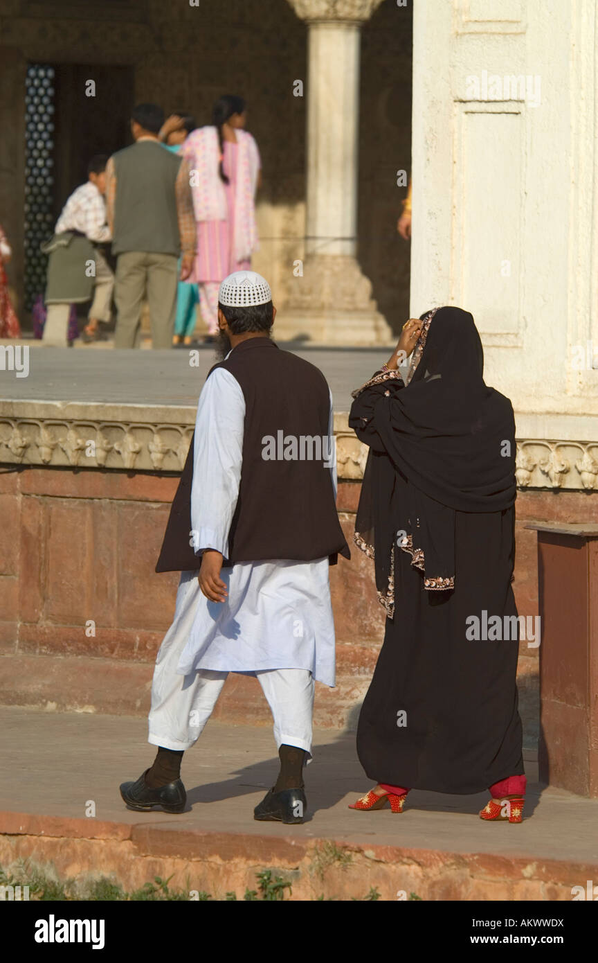 A Muslim couple walks through the gilded architecture of the historic Red Fort (Lal Qila) in Old Delhi, India. - Stock Image